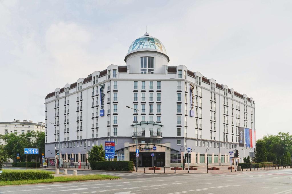 华沙索比斯基丽笙酒店的一座白色的大建筑,上面有一个圆顶