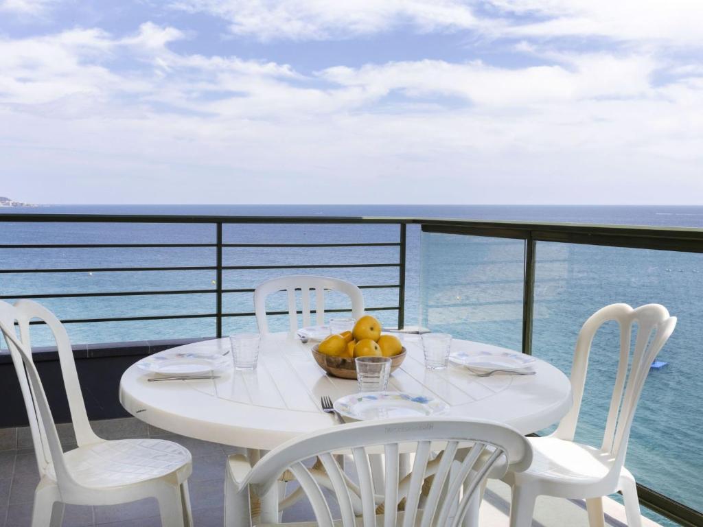 普拉加德阿罗Apartment Fanals-1 by Interhome的阳台上配有一张带椅子的白色桌子和一碗水果
