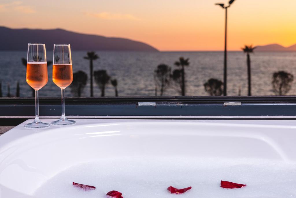 伏罗拉Azar Luxury Suites的桌子上放两杯酒,享有海景