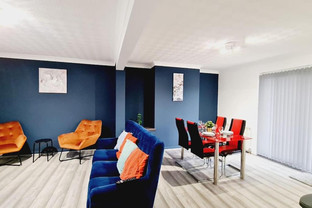 达特福德Saint Johns 3-bedroom House-Greater London的客厅设有蓝色的墙壁、蓝色的沙发和桌子