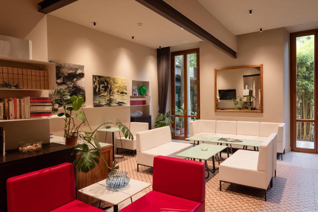 佛罗伦萨卡拉瓦乔酒店的客厅配有白色家具和红色椅子