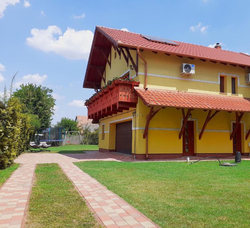 莫劳豪洛姆Klaudia Vendégház的黄色的房屋,有红色的屋顶