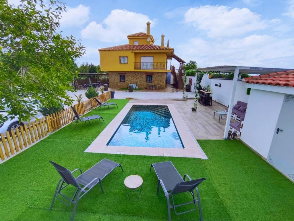 Cogollos de Guadix"El Coberteras"的后院设有游泳池、椅子和房屋
