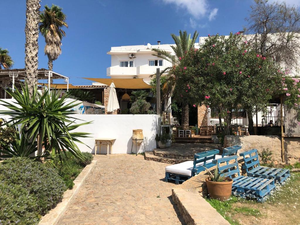 圣费兰-德瑟斯罗巴利阿里皮赛旅馆的一个带两个蓝色长椅的庭院和一座建筑