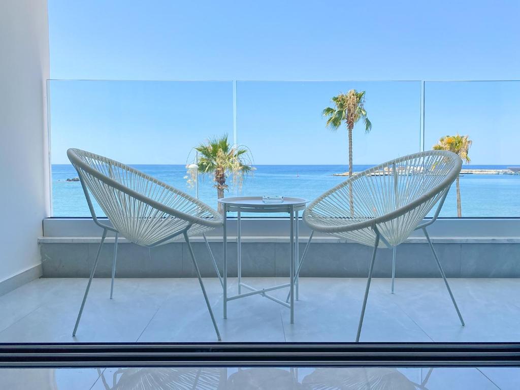 帕福斯Phaedrus Living: Marina Sea View Flat 214 Emerald的窗前的两把椅子和一张桌子