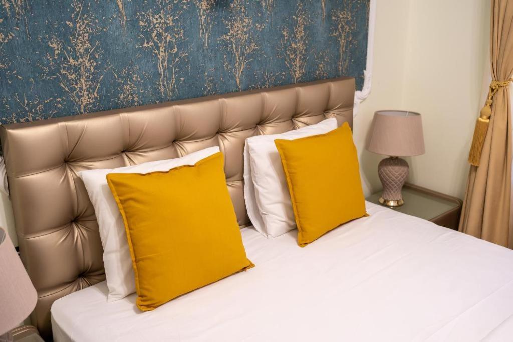 布加勒斯特Chic Boutique House的一间卧室配有一张带两个黄色枕头的床