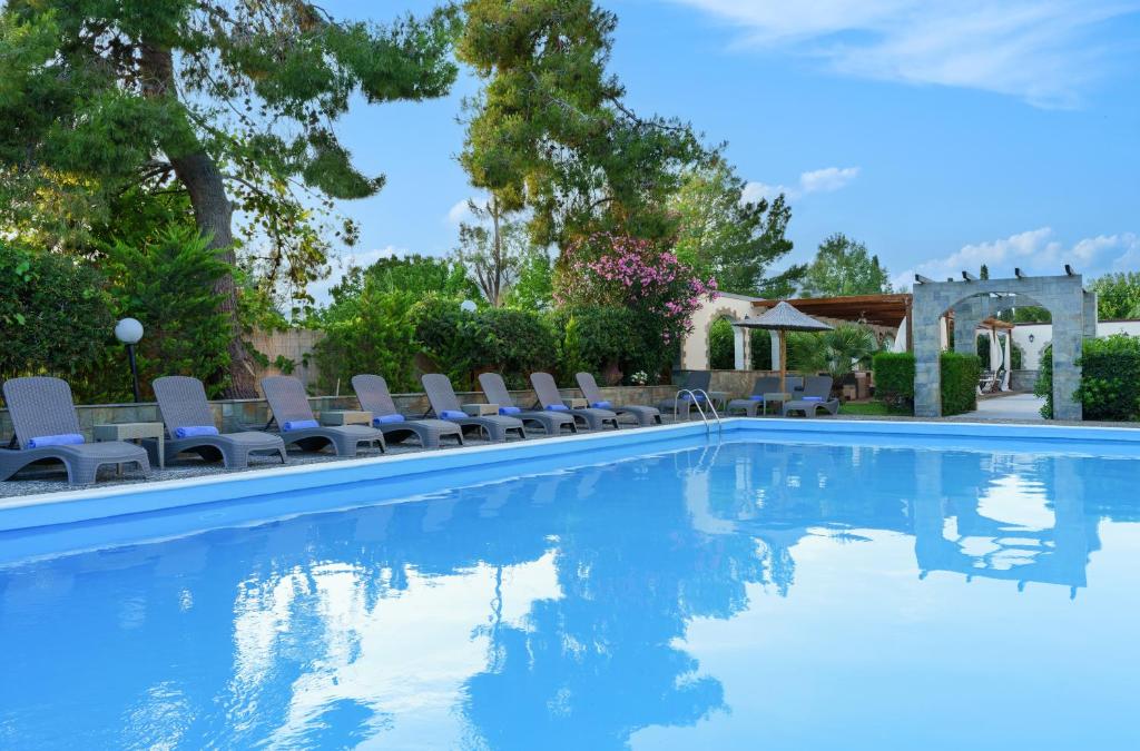 阿马林索斯Stefania Hotel的游泳池设有躺椅和树木