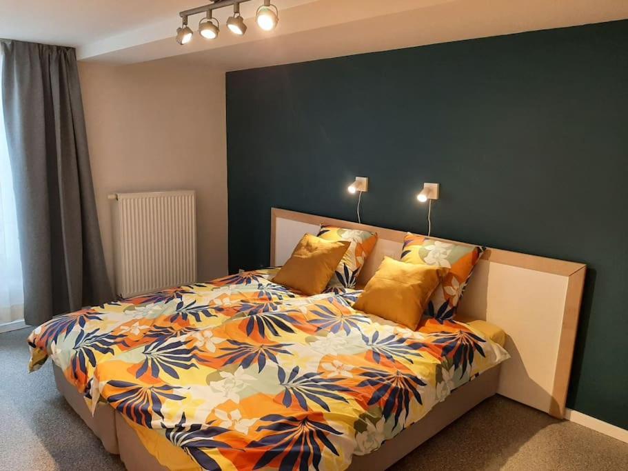 斯帕Au Grand Pierrot的一间卧室配有一张大床和色彩缤纷的被子