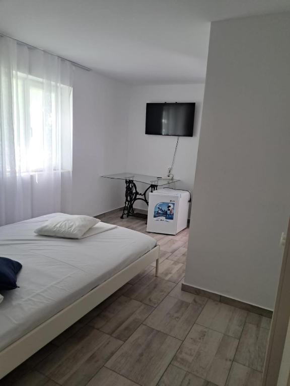 SchitulHotel Radarului Costinesti的一间白色卧室,配有床和电视