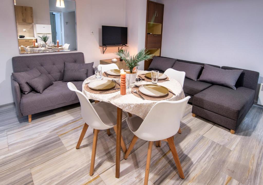 依克希亚Anali Apartment的餐桌、白色椅子和沙发