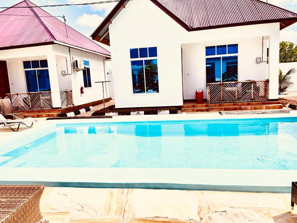 帕杰Mbuyu Uvi Apartment的别墅前设有游泳池