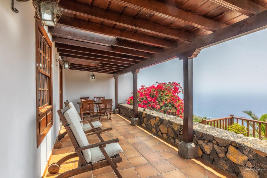 马佐Lightbooking La Morera Villa de Mazo con piscina的阳台设有椅子和石墙