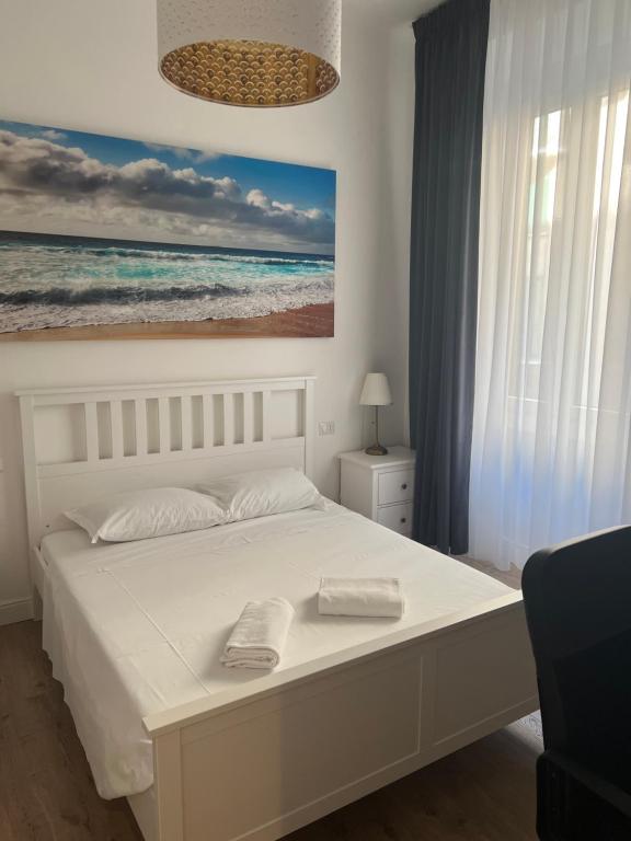 米兰P18&Rooms Palestrina 18的卧室配有白色的床和海洋绘画