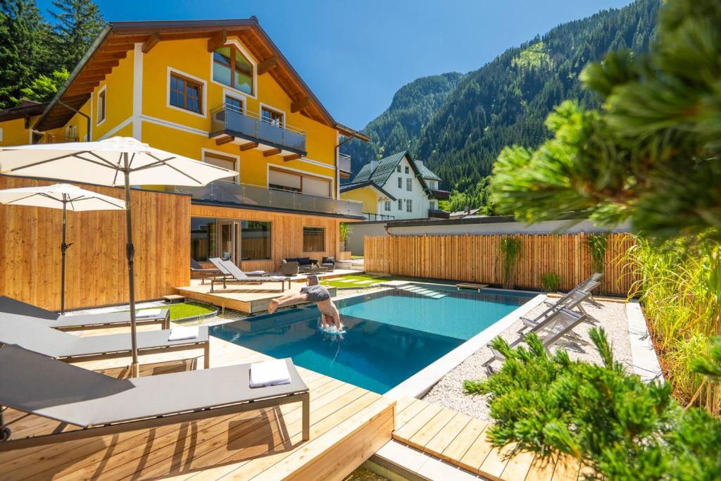 巴德加斯坦AlpinSpa zur Post的一座带游泳池和房子的度假屋