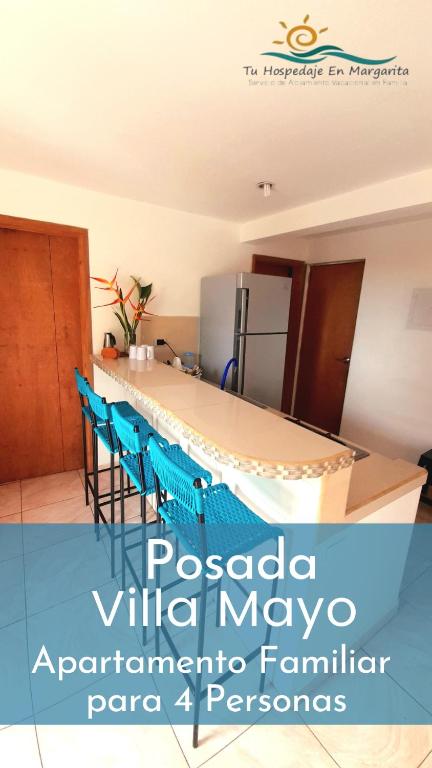 ParaguachiPosada Villa Mayo Apartamento Familiar a 5 Min de Playa Parguito的厨房配有桌椅和冰箱。