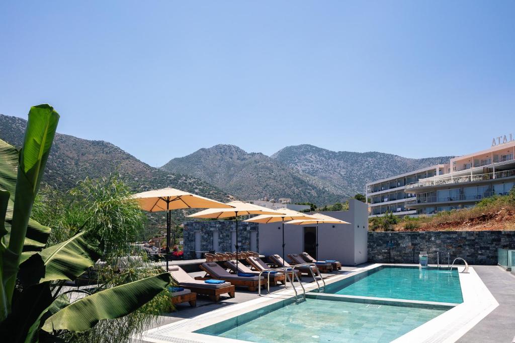 巴利恩Isla Villas & Suites的背景为一座带游泳池和山脉的酒店
