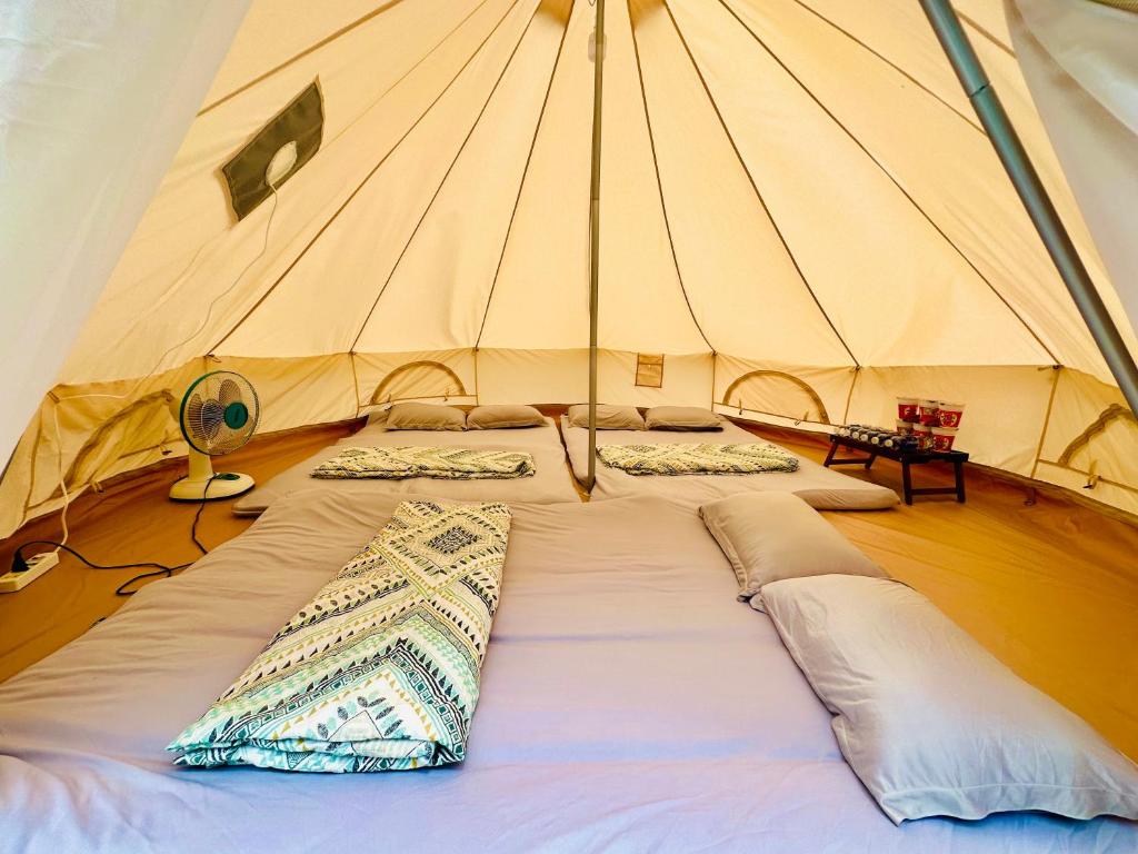 芹蒢SAY Camp Forest的帐篷内的一张大床,配有枕头