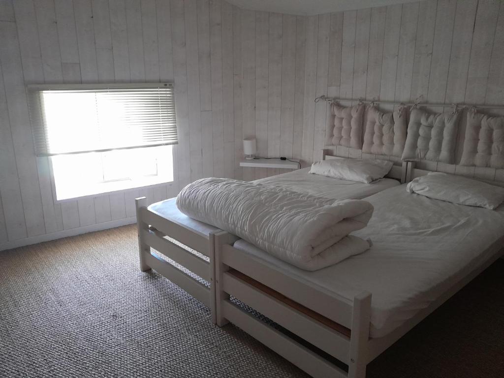 拉戈尔斯LA TERRASSE AUX HIRONDELLES avec SPA maison 80m2 2 chambres 2 salles de bains的卧室配有一张带白色床单的大床和窗户。
