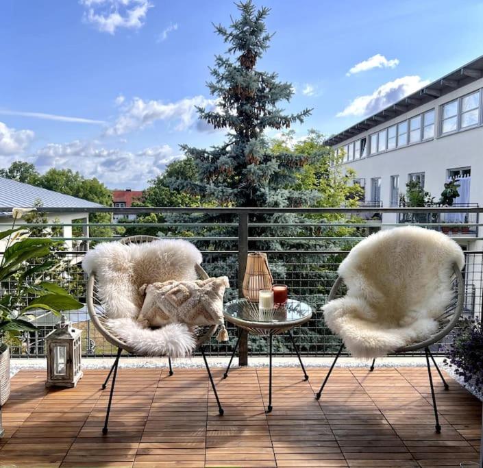 舍讷费尔德BALI HOME Stylische Wohnung mit Terrasse的天井配有两把椅子和一张桌子,上面有猫