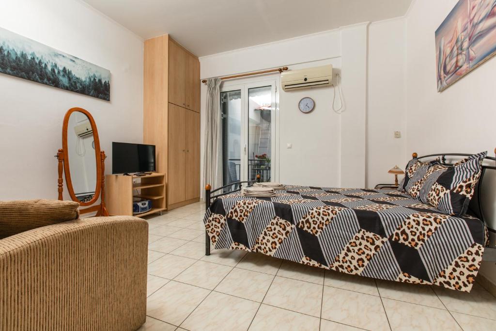 斯巴达Central Cozy Apartment的一间卧室配有一张床、一台电视和一张沙发