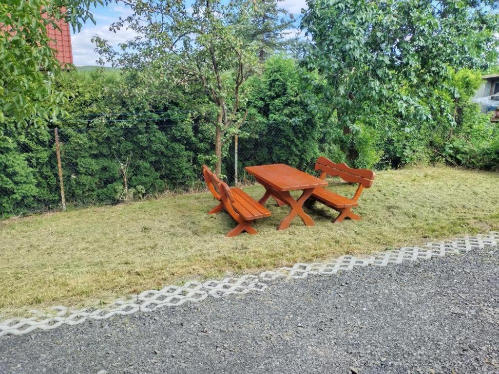 WieprzSzary Domek 2的草地上两个长椅和一张野餐桌