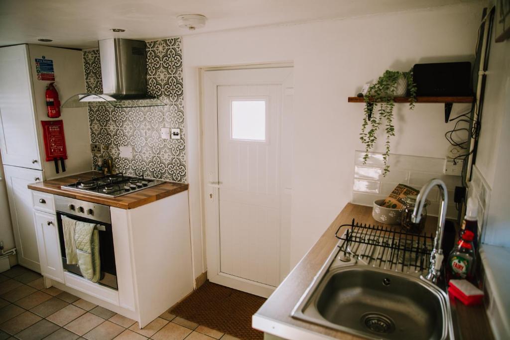 滨海凯斯特Pebbles Cottage的一间带水槽和炉灶的小厨房