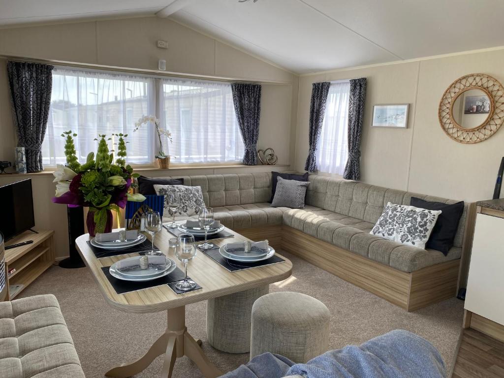 Littlestone-on-SeaComfy Cosy Caravan_Romney Sands的客厅配有沙发和桌子