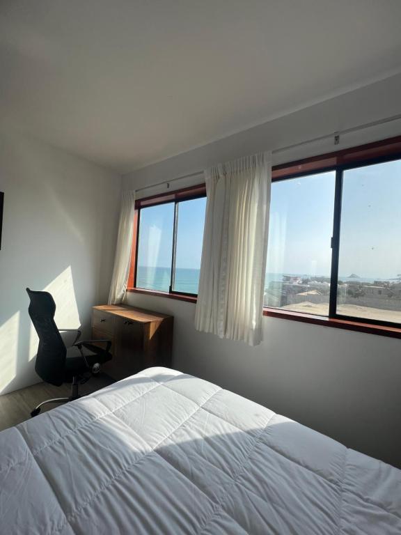 蓬塔赫尔莫萨Casablanca del Mar的一间卧室配有一张床、一把椅子和窗户。