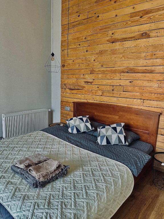 利沃夫Apart27的一间卧室设有一张带木墙的大床