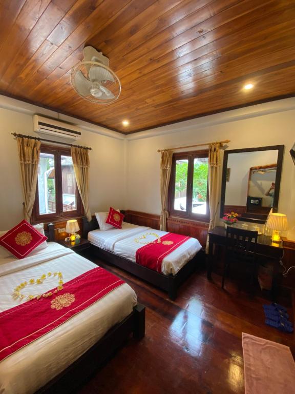 琅勃拉邦Golden Lotus Boutique Hotel的一间卧室配有两张床、镜子和一张书桌