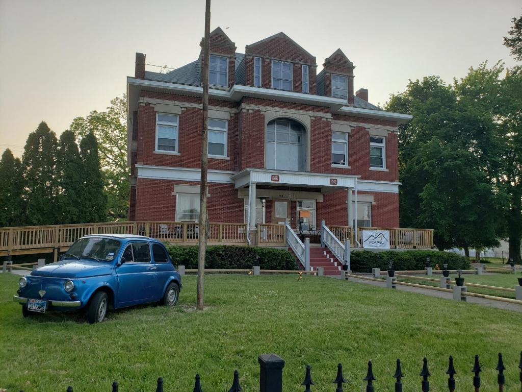 马里恩Beatrice The Villa的停在房子前面的一辆旧蓝色汽车