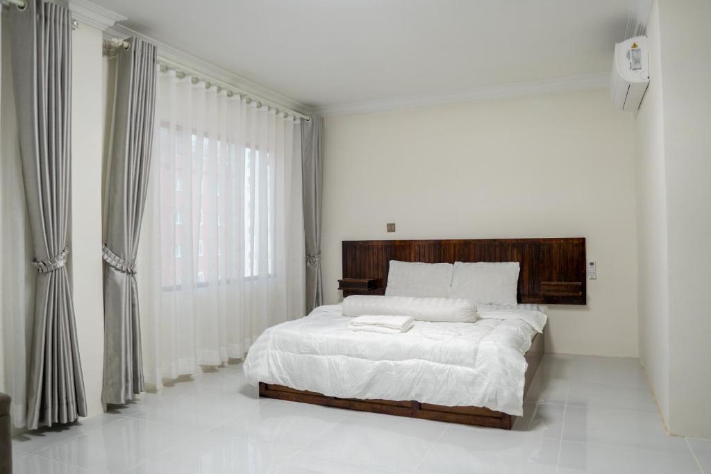 金边Empire House, Phnom Penh的白色的卧室设有床和大窗户