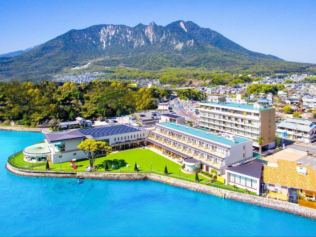 岛原市Hotel Seaside Shimabara的享有蓝色的海水和山脉的城市空中景致