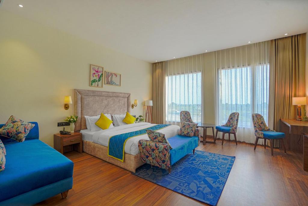 阿姆利则Hotel Escala By Levelup的酒店客房带一张床、一张桌子和椅子