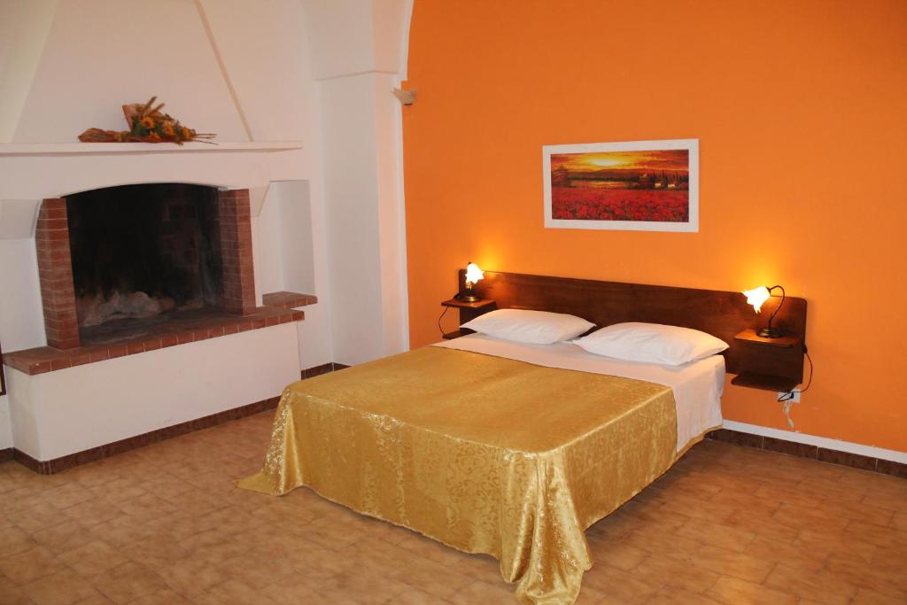 赛拉诺B&B Masseria Donna Carlotta的一间卧室配有一张床和一个壁炉