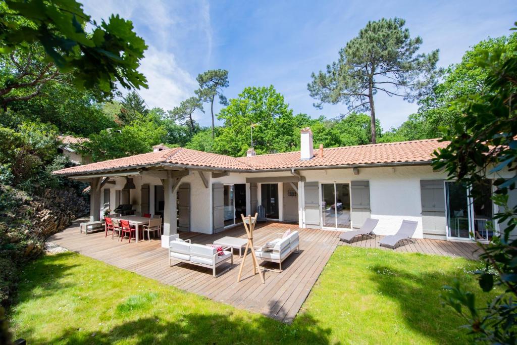 阿卡雄Villa de 4 chambres a Arcachon a 650 m de la plage avec jardin et wifi的庭院中带木甲板的房子