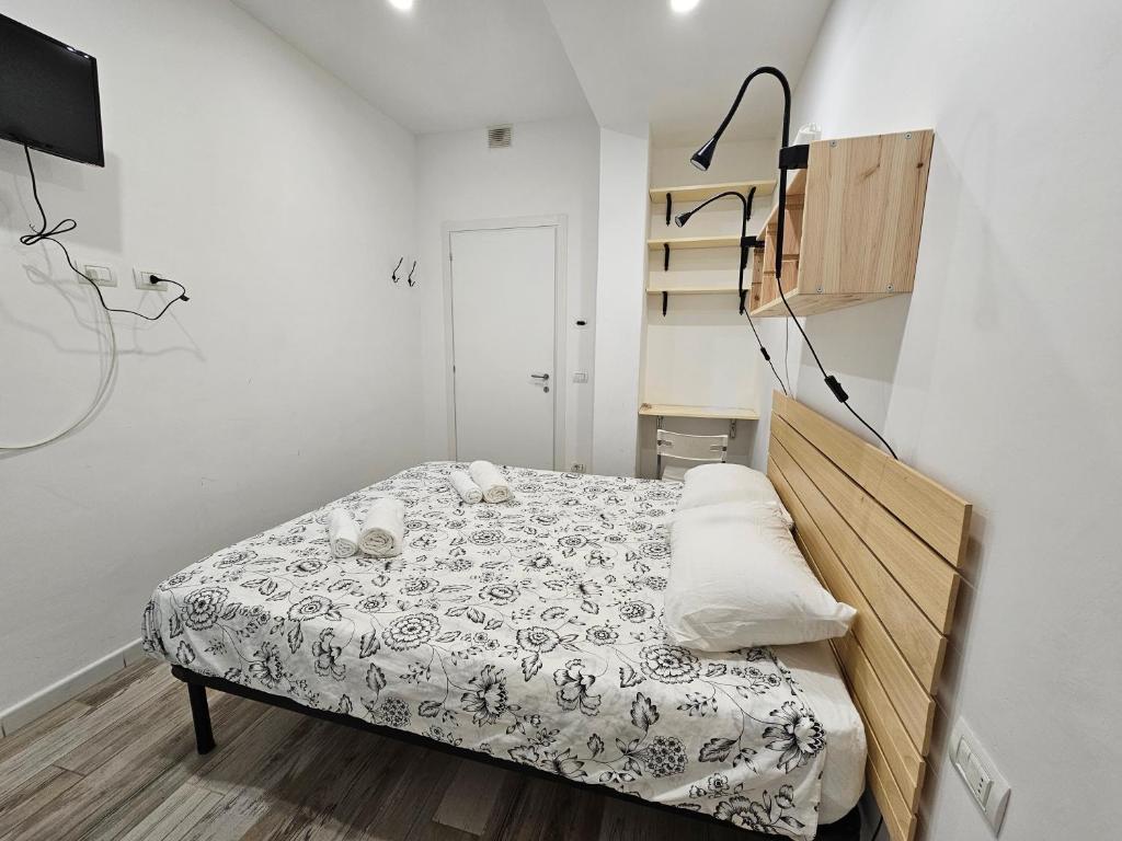 佛罗伦萨Kos的一间白色墙壁的房间,卧室配有床铺