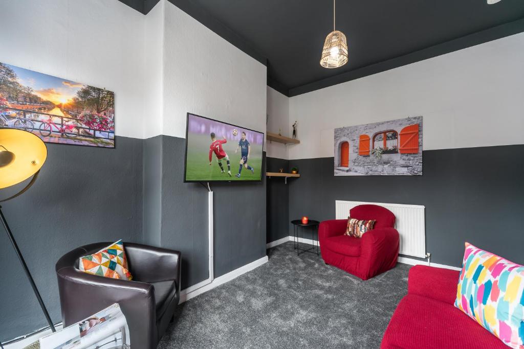 赫尔3 bedroom Shalom Sleeps 5 - Ideally Located in Hull的客厅配有红色沙发和电视