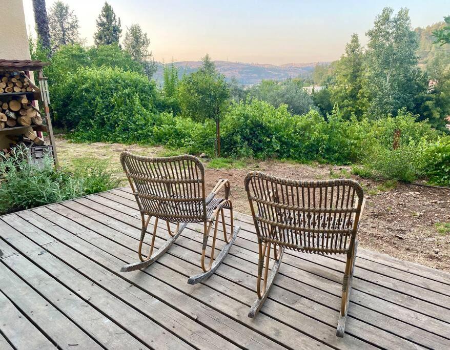 Bet ZayitLa Rustique Studio with a Spectacular View的两把椅子坐在一个享有美景的木甲板上