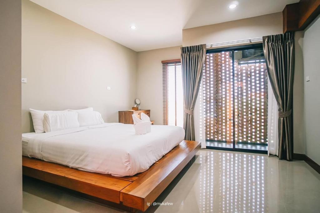素可泰Na Sukhothai Hotel的一间卧室设有一张床和一个大窗户