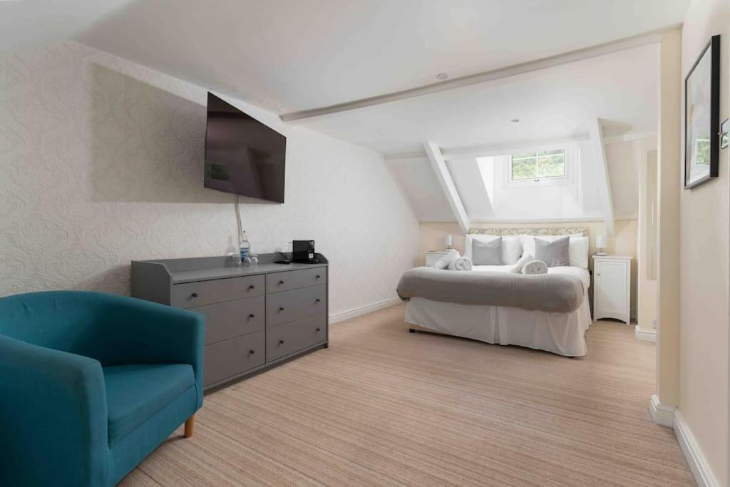 马拉扎恩Room 6, Hotel style Double bedroom in Marazion的一间卧室配有一张床、一台电视和一把椅子