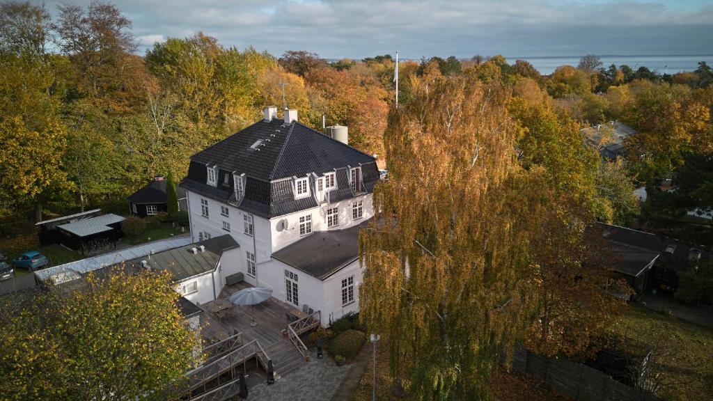 勒维Rørvig Centret的享有白色大房子空中美景,设有黑色屋顶