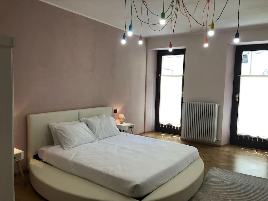 多莫多索拉Casa in centro Domodossola self check in的卧室设有一张白色大床和两个窗户。