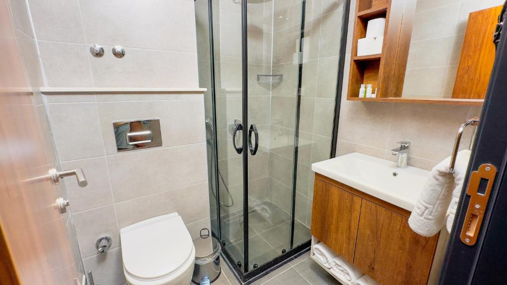 达特恰Feri Surf Club Hotel Datça的带淋浴、卫生间和盥洗盆的浴室