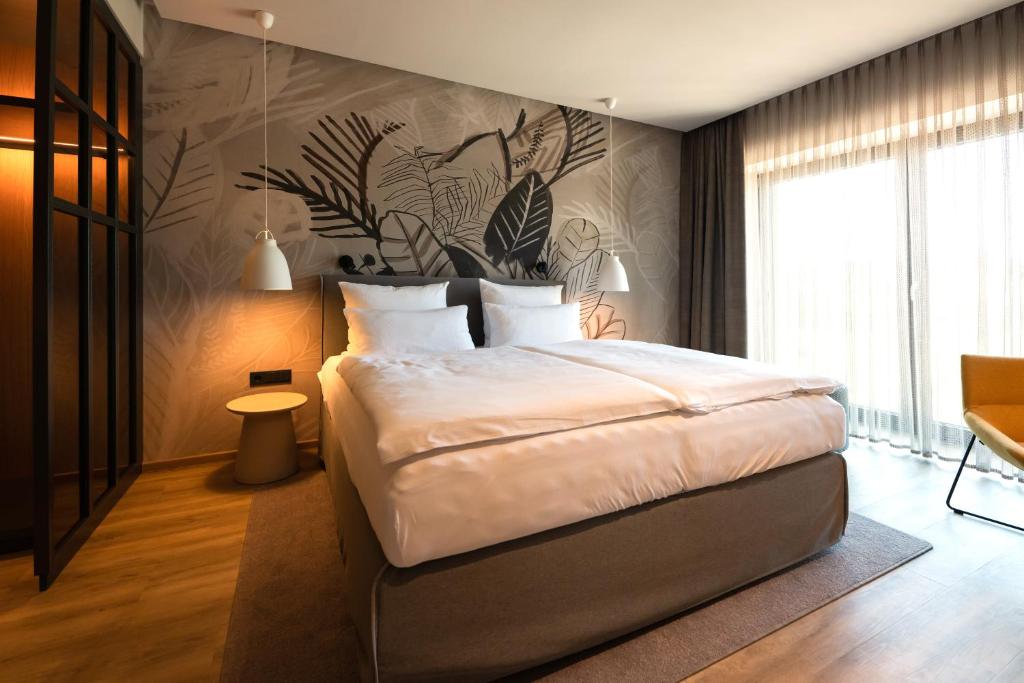 比肯Thöles Hotel Bücken的一间卧室设有一张大床和一堵植物墙