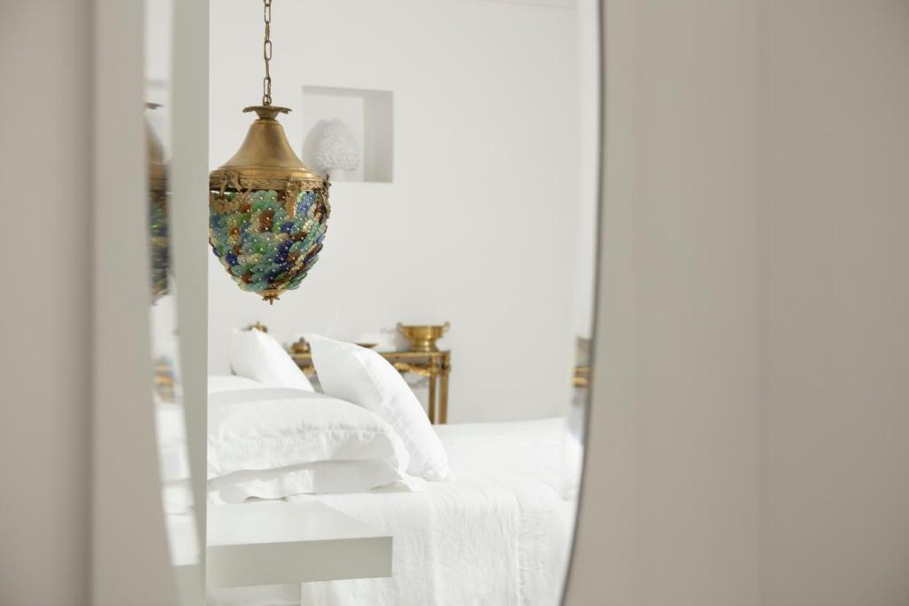 萨尔维Relais Carlo Alberto的卧室内的镜子,配有一张床和吊灯