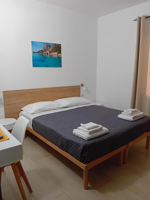 TrieiEliseo's rooms的一间卧室配有一张带蓝色毯子和一张桌子的床。