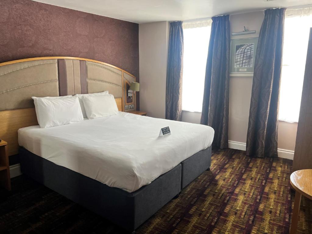 罗切斯特威瑟斯本金狮酒店的一间位于酒店客房内的带大床的卧室