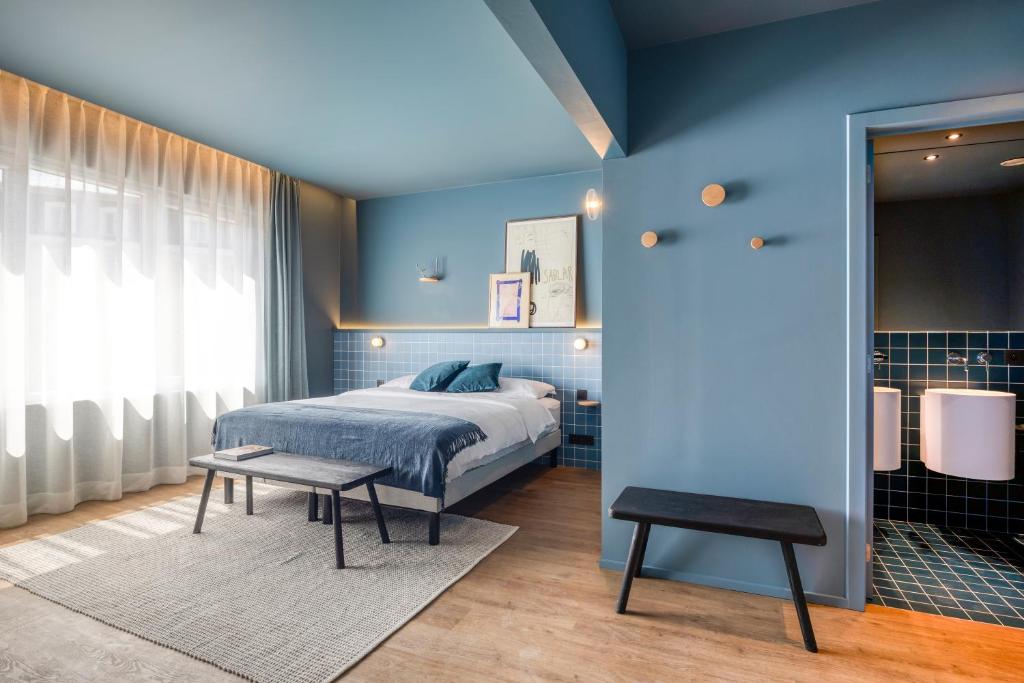 布鲁塞尔Maison Arya的一间卧室设有一张床和蓝色的墙壁