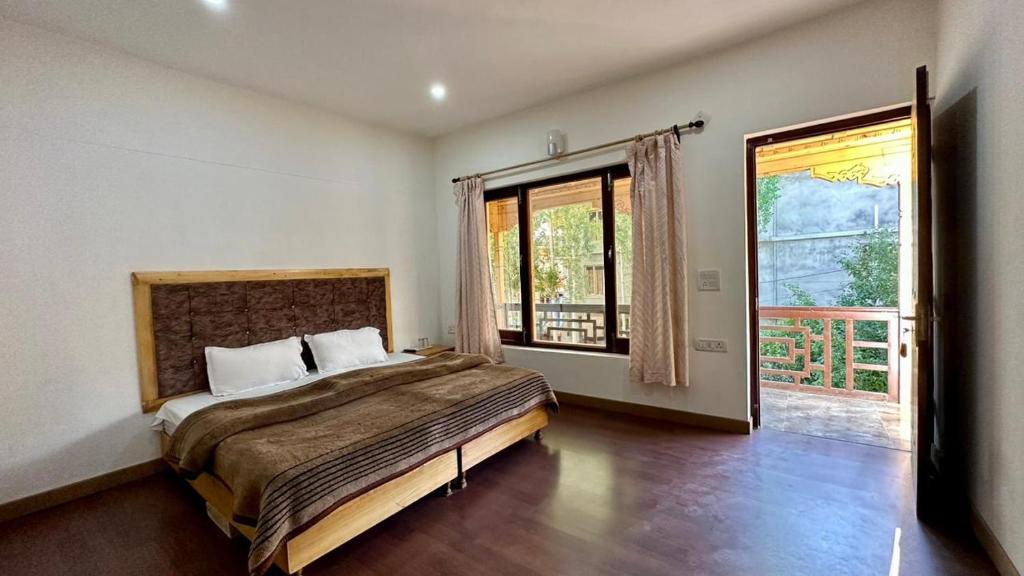 列城Nordan guest house Ladakhi room的一间卧室设有一张大床和一个大窗户